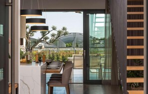 Enjoy meals in this open-plan living space with a dining area and sliding glass door leading to a garden.