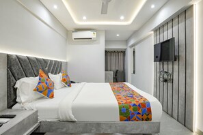 A modern hotel room with a large bed, a flat-screen TV, an air conditioning unit, and a bathroom visible in the background. - Fabhotel Aahan (Navi Mumbai)