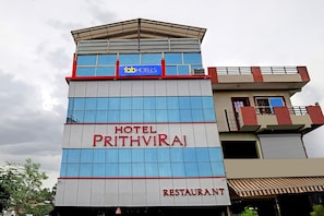 Un hotel llamado "Prithviraj" con un letrero que indica "fab hotels" y "restaurante" en el edificio.