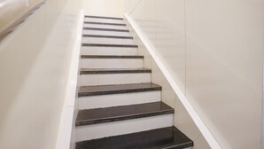 A staircase with white walls and black steps. - FabHotel Golden Star (Mumbai)
