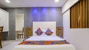 A modern bedroom with a large bed, a mirror, and a desk. - FabHotel Golden Star (Mumbai)