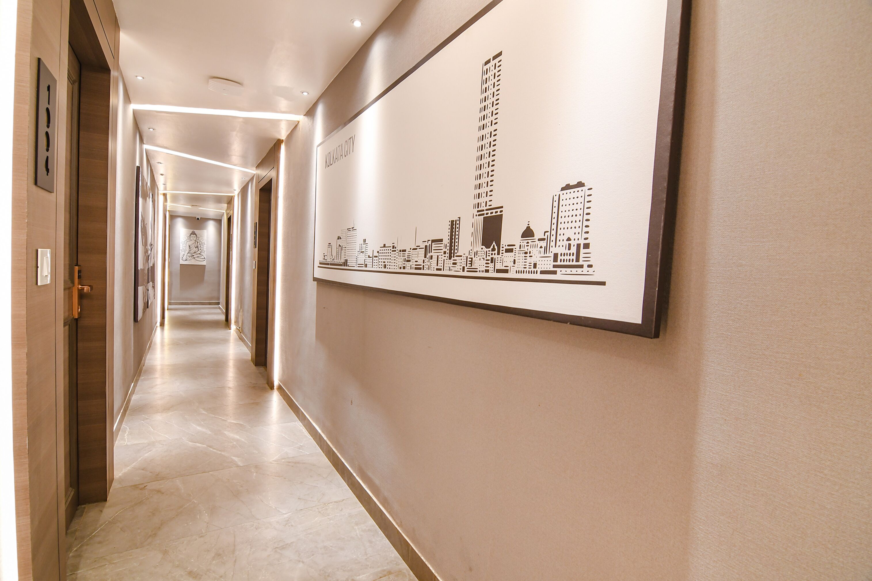 A hallway with a cityscape mural, marble flooring, and a door on the left.