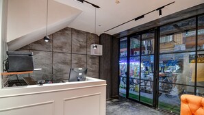 Una reception dal design moderno, con un computer e una televisione. Grande finestra con vista sulla strada.