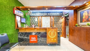 A reception area with a sign reading "RAJ SUPREME RESIDENCY," a marble counter, and a logo for "fab express." - Fabexpress Raj Supreme Residency (Chennai)