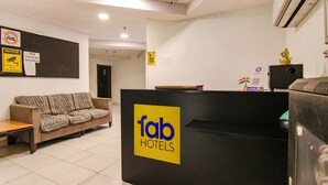 A reception area with a 'fab hotels' sign, a sofa, a desk, and a wall-mounted security camera. - Fabhotel Moro Rohini Sector 11 (New Delhi)