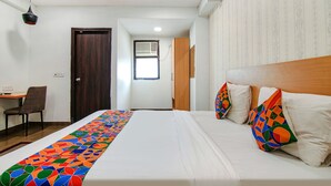 A hotel room with a bed, a desk, a chair, and a door. - Fabhotel Moro Rohini Sector 11 (New Delhi)