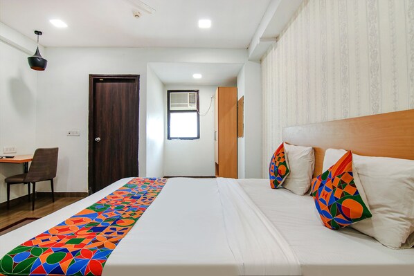 A hotel room with a bed, a desk, a chair, and a door. - Fabhotel Moro Rohini Sector 11 (New Delhi)