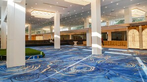 A spacious lobby with a blue patterned carpet, large chandeliers, and a seating area with a view of the outdoors. - Fabhotel Dreams Inn (Thane)