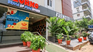 Een hotelingang met een bordje voor 'Frenotel' en 'Brand of Food Lovers'.