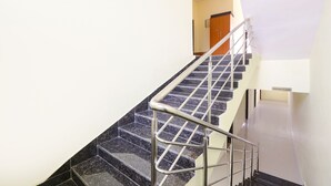 A staircase with a metal handrail leading to a landing.
