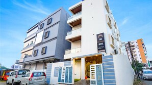 Un hotel moderno con un llamativo letrero de 'Fab Hotels', una entrada visible y una vista despejada del entorno urbano.