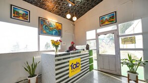 A hotel reception area with a marble counter, a 'Tab Hotels' sign, and artwork on the walls. - Fabhotel Sizzling Resort & Adventure (Dhanaulti)
