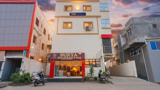 A building with a sign for 'Surya Restaurant & Bar' at the ground level. - FabHotel Surya I Pune (Rajgurunagar)