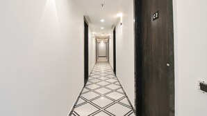 Un couloir doté d’un sol carrelé, d’une porte portant l’inscription « C2 » et d’un éclairage encastré.