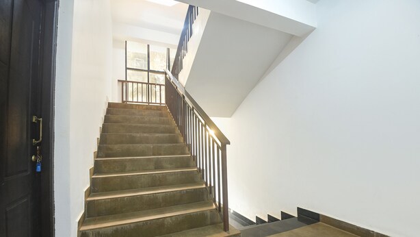 A staircase with a metal railing, leading to an upper floor. - FabHotel Holiday Suites - Nr. Benaulim Beach (Benaulim)