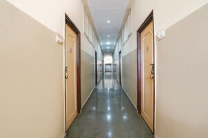 Um corredor longo e estreito, com portas de ambos os lados dando acesso a quartos.