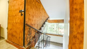 A wooden staircase with a metal railing leading to a room with a window. - Fabhotel Grand Royal Palms (Benaulim)