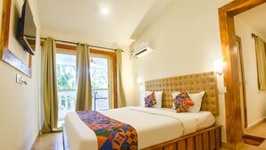 A bedroom with a large bed, a television mounted on the wall, and an air conditioning unit. - Fabhotel Grand Royal Palms (Benaulim)