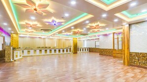A spacious room with a wooden floor, a reception desk, and a decorative ceiling with floral patterns. - Fabhotel Prime Ravila Grand (Hyderabad)