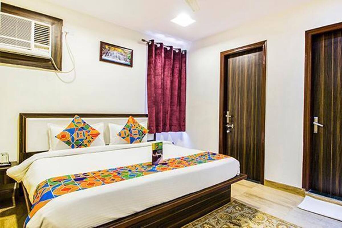 Un dormitorio con cama, armario, puerta, ventana y aire acondicionado.