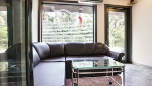 A modern living room with a leather sofa and a glass coffee table. - Fabhotel Sai Vihar (Thane)