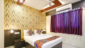 A bedroom with a bed, nightstand, wall-mounted lights, an air conditioner, and a window with curtains. - Fabhotel Sai Vihar (Thane)