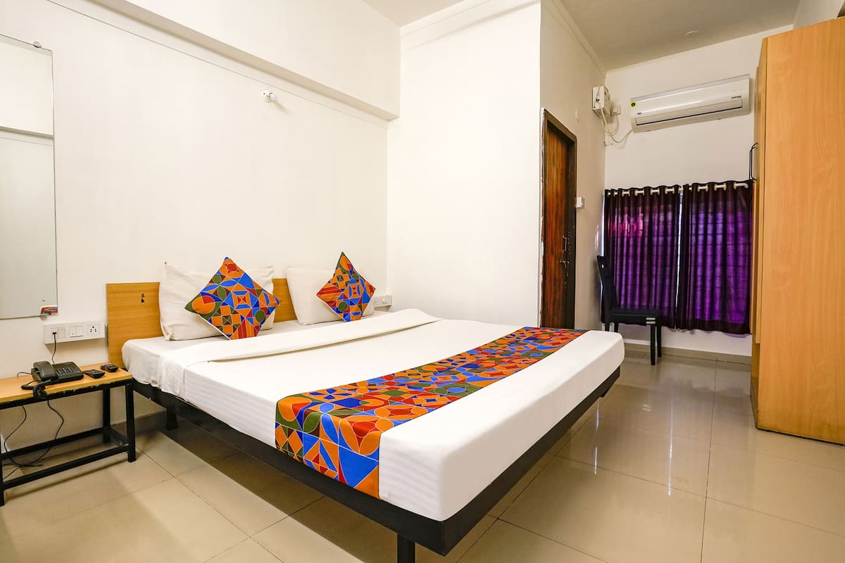 Une chambre d’hôtel équipée d’un lit, d’une table de chevet et d’un appareil de climatisation.