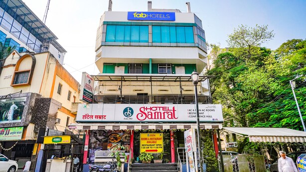 A hotel with a sign for 'fab hotels' and 'Samrat Hotel' with a restaurant open from 7:00 AM to 11:00 PM. - Fabhotel Samrat (Nashik)