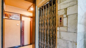 An elevator with a digital display showing the number 3, a metal gate, and a marble wall. - Fabhotel Samrat (Nashik)