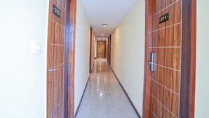 A hallway with wooden doors, each marked with a number. - Fabhotel Prime Signature Inn (Bengaluru)