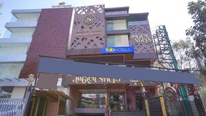 A multi-story building with a 'Signature Inn' and 'Magical Spices' sign. - Fabhotel Prime Signature Inn (Bengaluru)