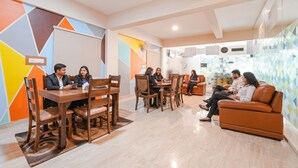 Um espaço de escritório moderno com uma mesa de conferência, um sofá e uma área de reuniões.