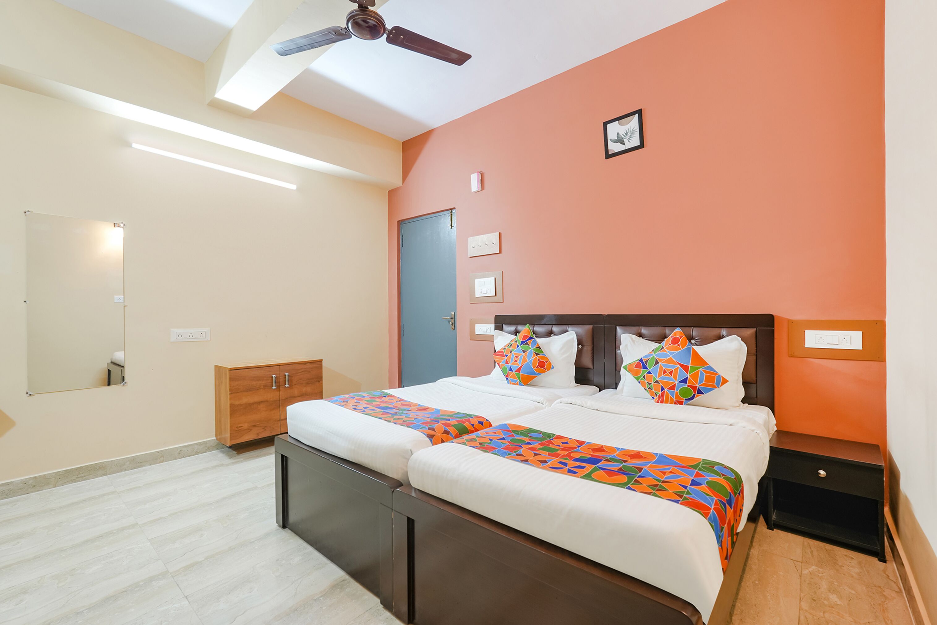 A hotel room with a bed, a nightstand, a wardrobe, a ceiling fan, and a door.
