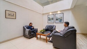 Un interior moderno con dos sofás de cuero, una mesa de centro y obras de arte en las paredes.