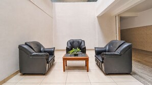 Un interior moderno con un techo alto, un tragaluz de vidrio y una mesa central con dos sillas.