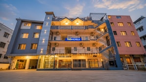 A multi-story hotel with a prominent 'fabHOTELS' sign, multiple balconies, and a central entrance with a covered area. - FabHotel Ivory Pearl Koramangala Bangalore (Bengaluru)
