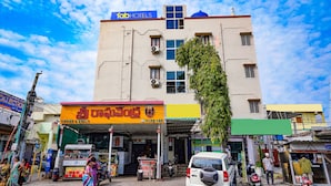 A hotel with a signboard for 'fabHOTELS' and a shop with a signboard in a local language. - Fabexpress Venkateswara Atidhi (Hyderabad)