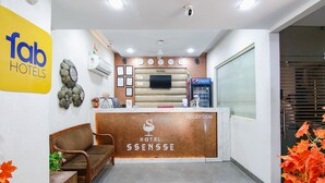 A hotel reception area with a reception desk, a clock, a television, and a Pepsi refrigerator. - Fabhotel Ssensse (New Delhi)
