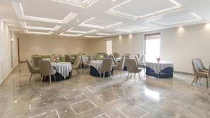 A spacious conference room with a polished marble floor, multiple tables with chairs, and geometric ceiling lighting. - Fabhotel Prime Royal Court (Ludhiana)