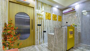 A reception area with a marble floor, a reception desk, a gold door, and a sign for 'fab hotels'. - FabHotel Shubh Hari (Jaipur)