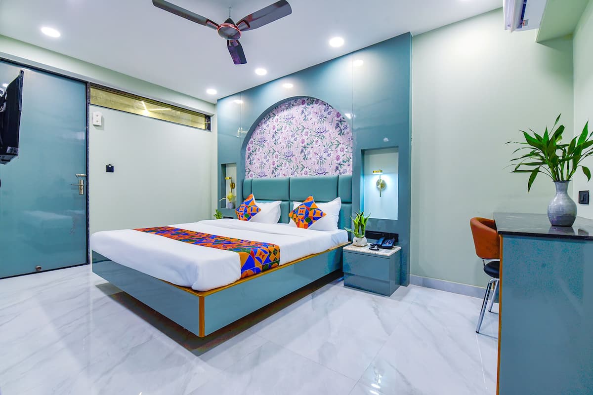 Un dormitorio moderno con cama, mesita de noche y zona de escritorio.