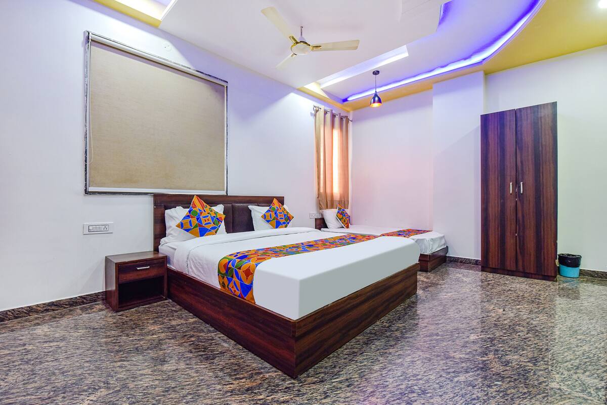 A bedroom with a bed, nightstand, wardrobe, and ceiling fan.