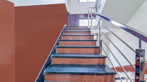 A staircase with metal railings and a red wall. - FabHotel Diamond Inn (Jaipur)