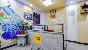 A reception area with a peacock mural, a reception desk, a television, and a 'Key' sign. - FabHotel Diamond Inn (Jaipur)