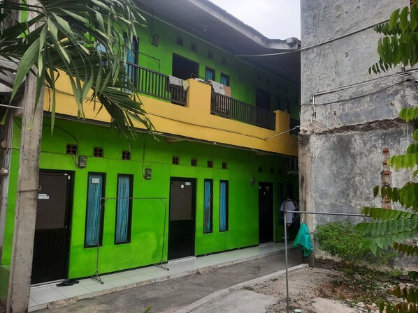 A two-story building with a green facade and a yellow upper section. - OYO Life  93023 Kost Bulan Karawang (Karawang)
