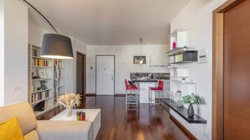 Ein modernes Apartment mit Wohnzimmer, Küche und Essbereich.