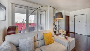 A modern living room with a sofa, a bookshelf, and a large window. - BnButler - Celio, 11 (Milano)