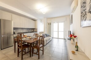 Una cocina moderna con comedor, sofá y un amplio ventanal.