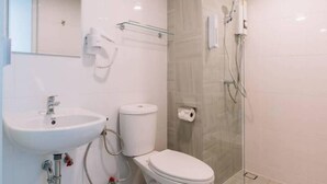 Un bany modern amb un lavabo, vàter i una dutxa amb envà.