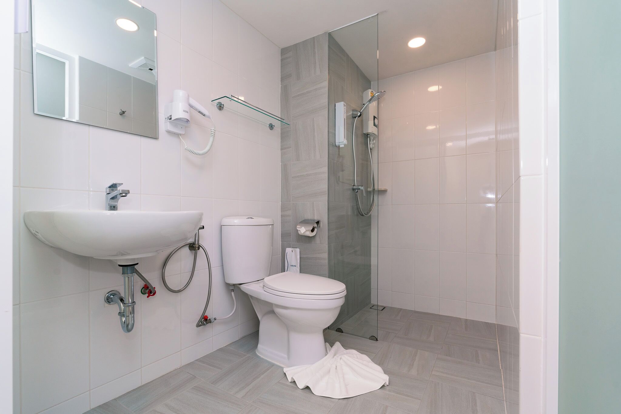 A modern bathroom with a sink, toilet, and shower.